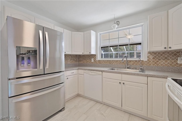 kitchen featuring decorative backsplash, sink, white cabinets, and white appliances