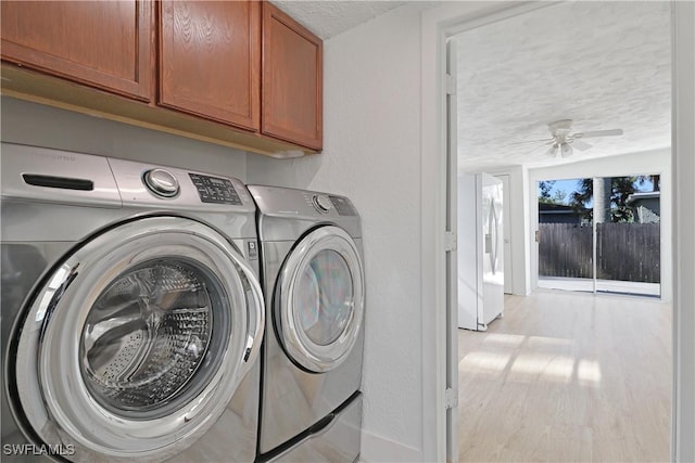 washroom with cabinets, a textured ceiling, ceiling fan, washing machine and clothes dryer, and light hardwood / wood-style floors