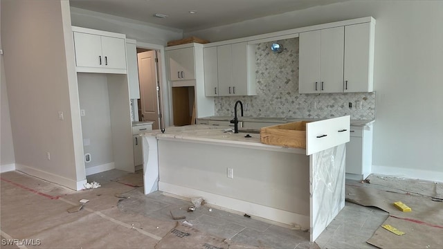 kitchen featuring tasteful backsplash and white cabinetry