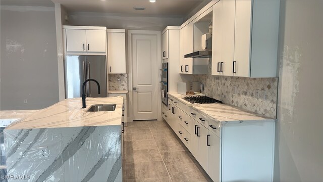 kitchen featuring white cabinetry, stainless steel appliances, light stone counters, and backsplash