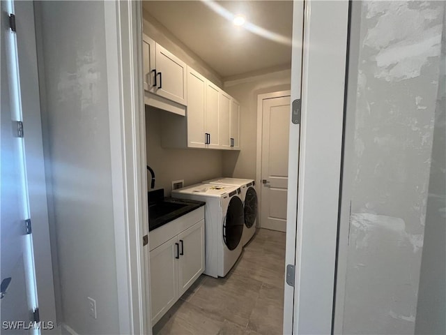 laundry area featuring a sink, cabinet space, and washer and clothes dryer