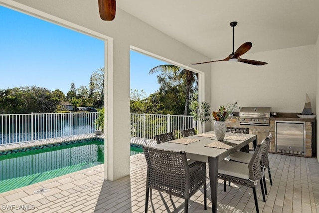 4584 W Alhambra Cir, Naples, FL 34103 - view of patio / terrace featuring a fenced in pool, grilling area, a water view, ceiling fan, and exterior kitchen