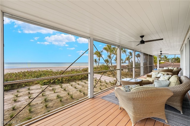 sunroom / solarium featuring ceiling fan, a water view, wood ceiling, and a view of the beach