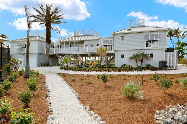 view of front facade featuring a garage, a balcony, and central AC