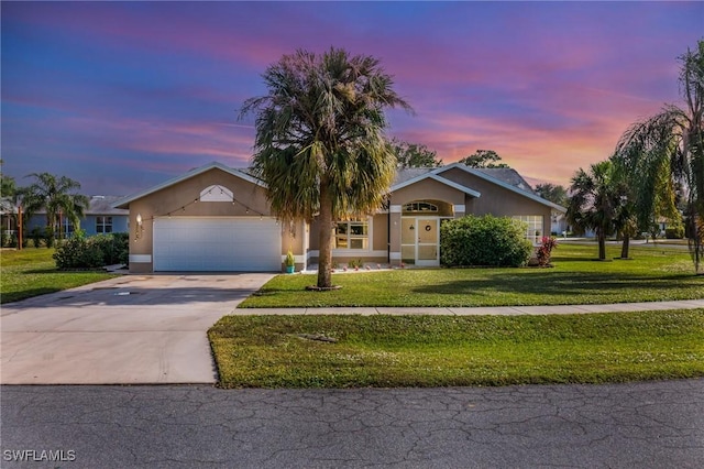 ranch-style house with a yard and a garage