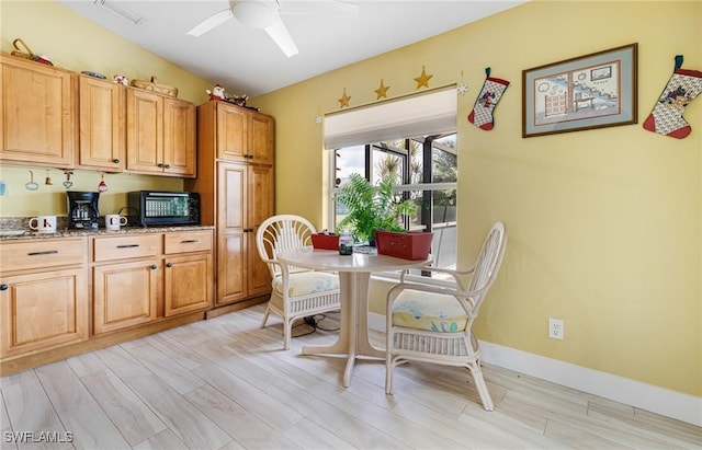 kitchen with ceiling fan, light stone countertops, and light wood-type flooring