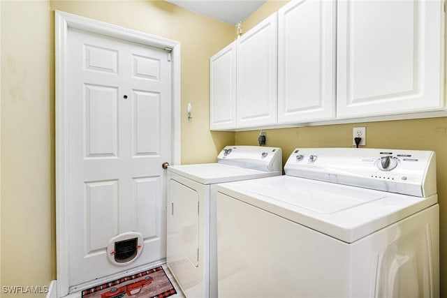 laundry room featuring cabinets and washing machine and clothes dryer