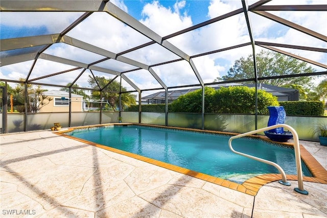 view of pool with a patio and glass enclosure