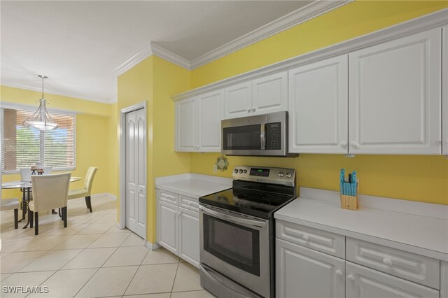 kitchen featuring appliances with stainless steel finishes, ornamental molding, white cabinetry, hanging light fixtures, and light tile patterned flooring