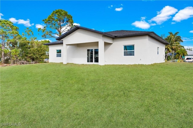 rear view of property featuring a lawn