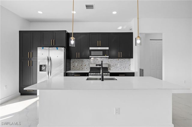 kitchen featuring pendant lighting, sink, an island with sink, tasteful backsplash, and stainless steel appliances