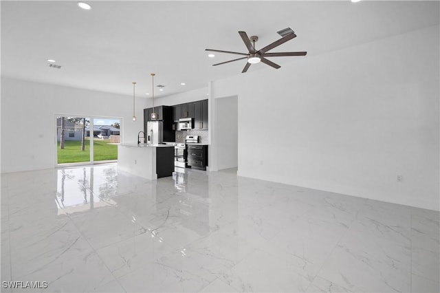 unfurnished living room with ceiling fan and sink