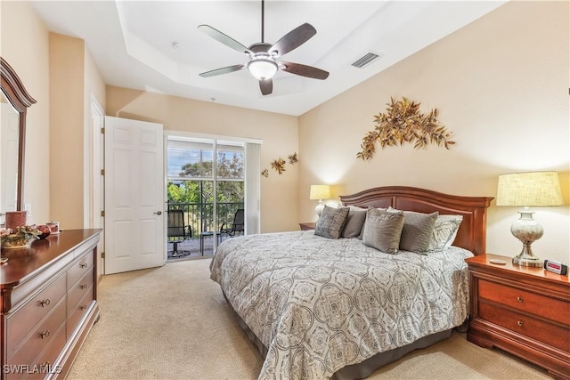 carpeted bedroom with access to outside, a raised ceiling, and ceiling fan