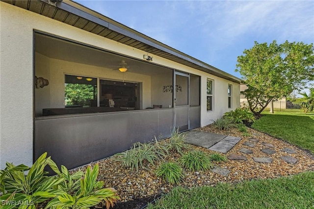 doorway to property featuring ceiling fan and a yard