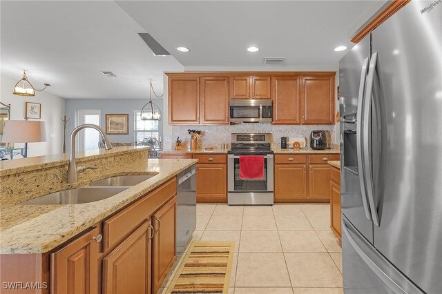 kitchen featuring sink, hanging light fixtures, stainless steel appliances, a chandelier, and light tile patterned flooring