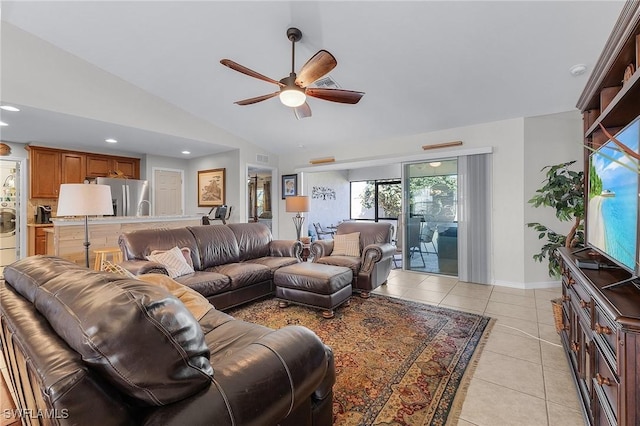 living room with light tile patterned floors, vaulted ceiling, and ceiling fan