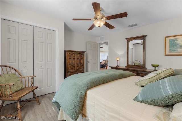 bedroom featuring a closet, light hardwood / wood-style flooring, and ceiling fan