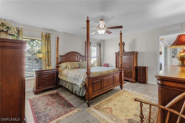 bedroom with multiple windows, ceiling fan, and light hardwood / wood-style flooring