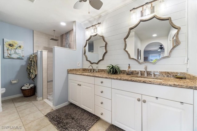 bathroom with a tile shower, vanity, and ceiling fan