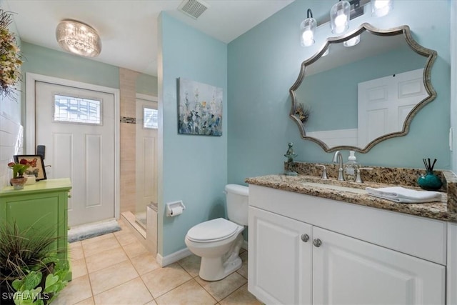 bathroom with tile patterned flooring, a shower, vanity, and toilet