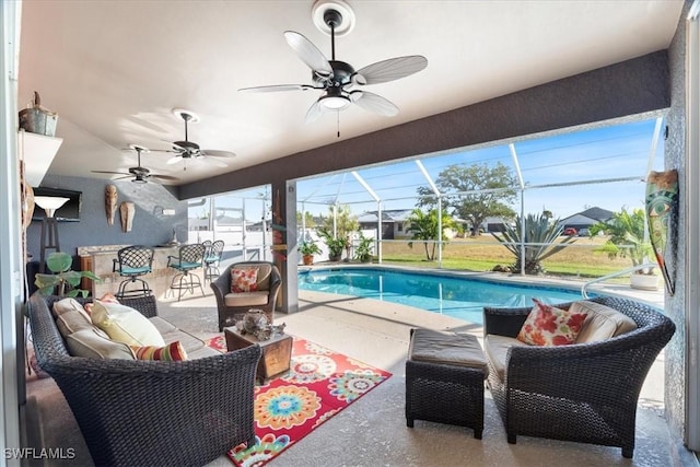 view of swimming pool featuring ceiling fan, a patio area, a lanai, and an outdoor hangout area