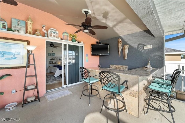 view of patio / terrace with a bar and ceiling fan