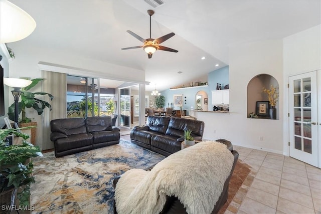 tiled living room with ceiling fan with notable chandelier, vaulted ceiling, and french doors