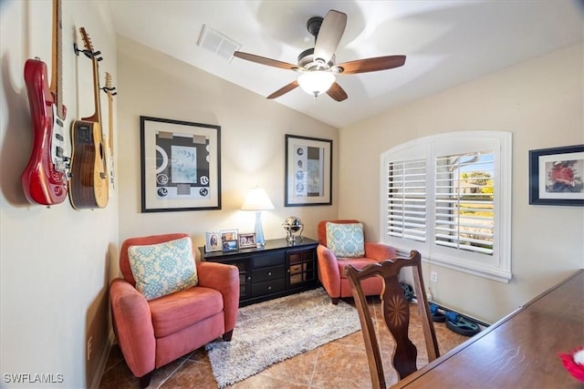 home office featuring ceiling fan, dark tile patterned flooring, and vaulted ceiling