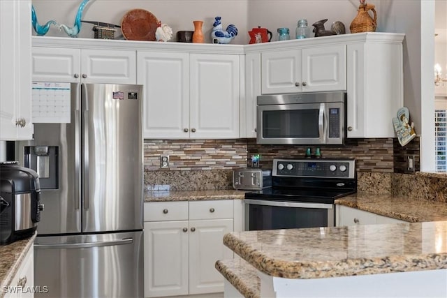 kitchen featuring light stone counters, white cabinetry, appliances with stainless steel finishes, and tasteful backsplash