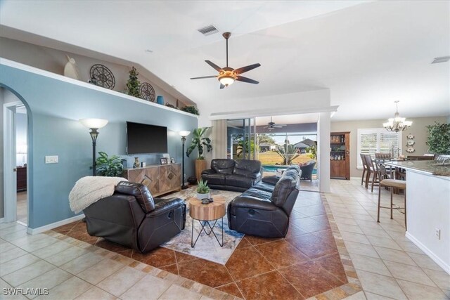 tiled living room with ceiling fan with notable chandelier and lofted ceiling