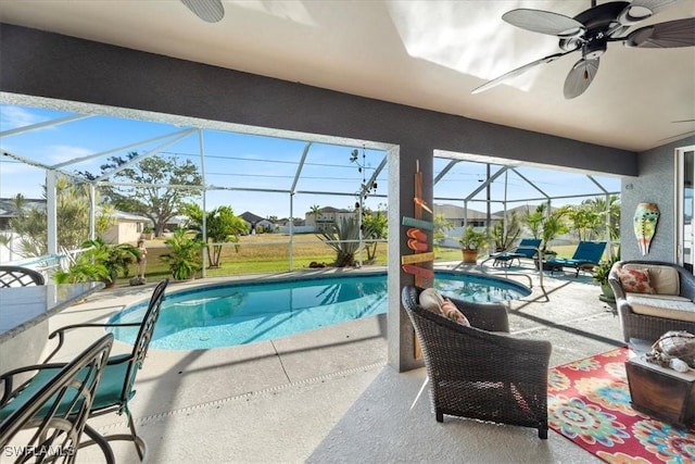 view of swimming pool with ceiling fan, exterior bar, and glass enclosure