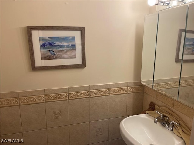 bathroom with sink and tile walls