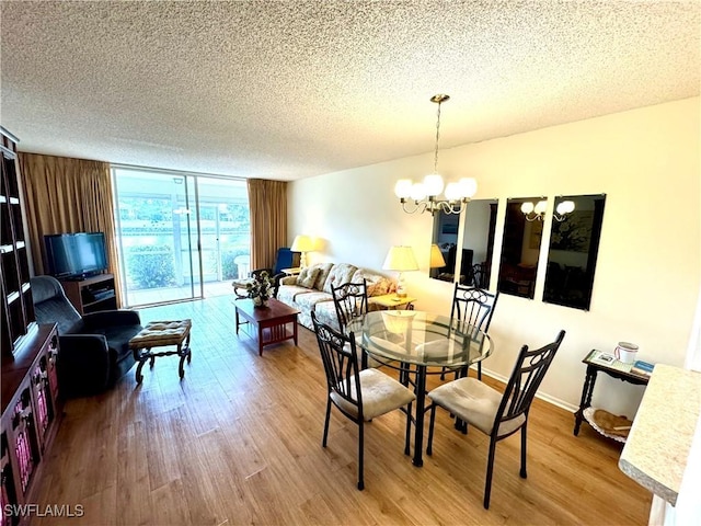 dining area with hardwood / wood-style floors, floor to ceiling windows, a textured ceiling, and a chandelier