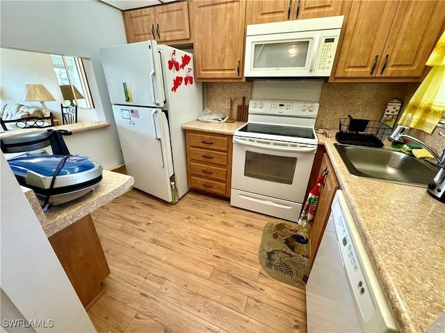 kitchen featuring light hardwood / wood-style floors, white appliances, sink, and tasteful backsplash