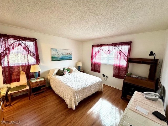 bedroom featuring wood-type flooring and a textured ceiling