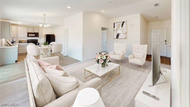 living room with a chandelier and light wood-type flooring