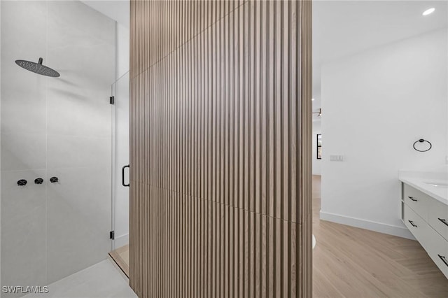 bathroom featuring hardwood / wood-style flooring, vanity, and a shower with door