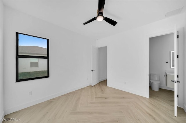 unfurnished bedroom with ceiling fan, light parquet flooring, and ensuite bath