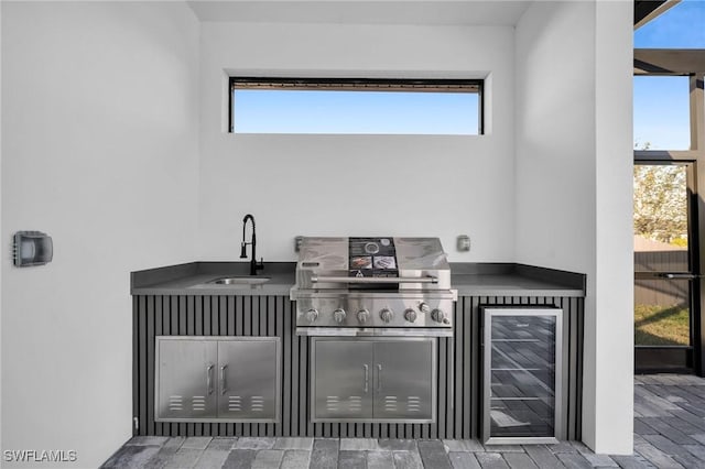 view of patio with a grill, sink, beverage cooler, and an outdoor kitchen