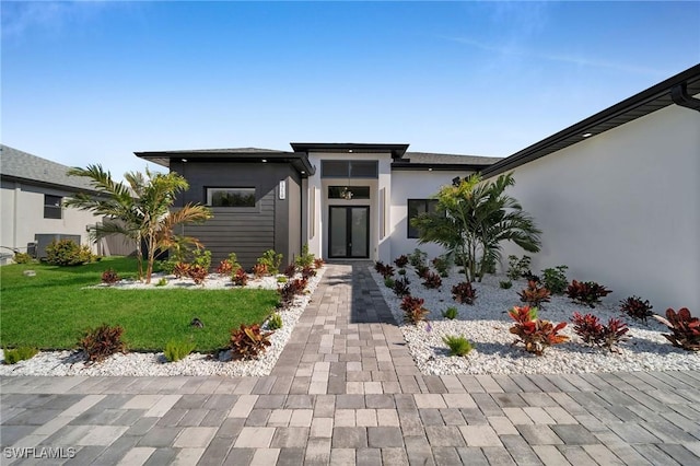 view of front of property featuring central AC and a front lawn