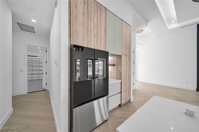 kitchen with stainless steel refrigerator and light hardwood / wood-style floors