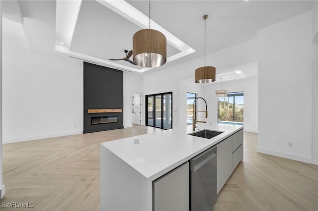 kitchen with dishwasher, a center island with sink, decorative light fixtures, and sink