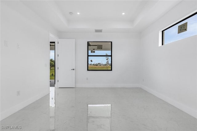 unfurnished room featuring a tray ceiling