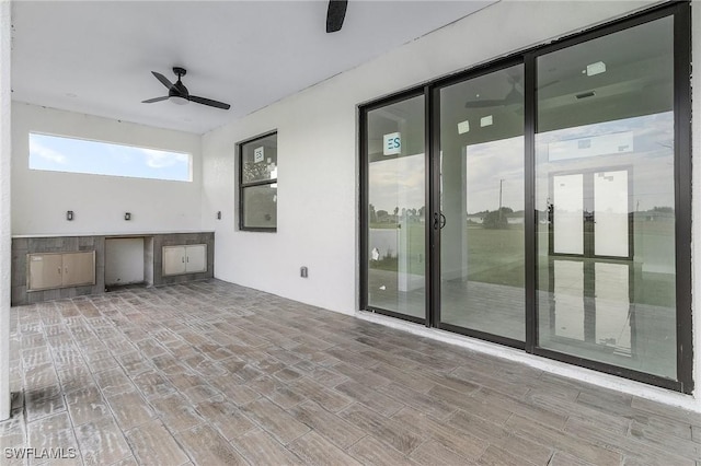 view of patio with an outdoor kitchen and ceiling fan