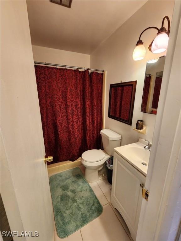 bathroom featuring tile patterned flooring, vanity, toilet, and a shower with shower curtain