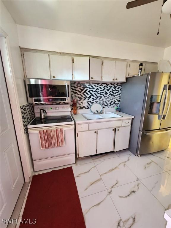 kitchen featuring decorative backsplash, sink, ceiling fan, and stainless steel appliances