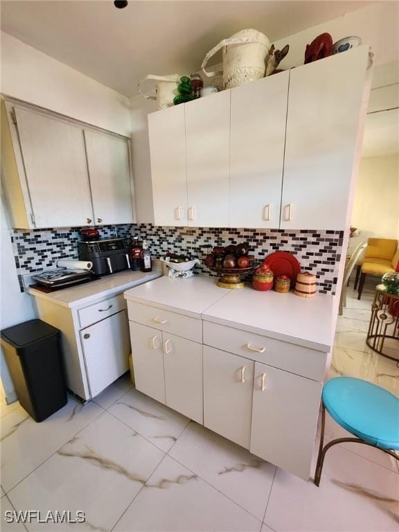 kitchen featuring backsplash and white cabinetry