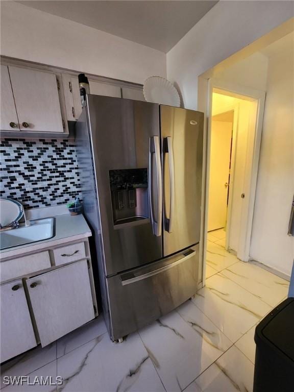 kitchen with stainless steel fridge and backsplash