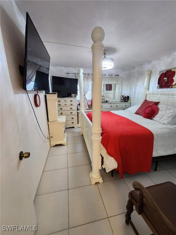 tiled bedroom featuring a textured ceiling and ceiling fan