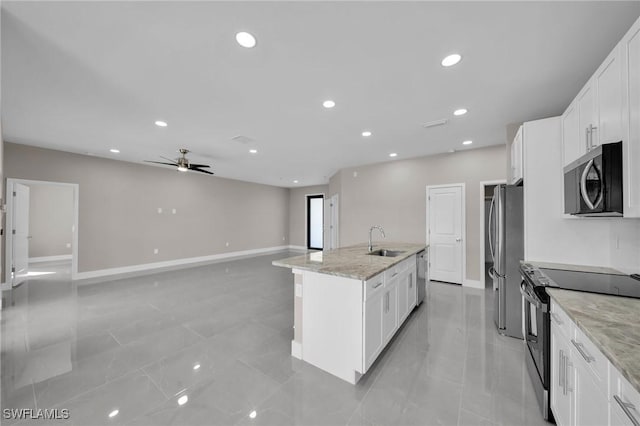 kitchen with light stone countertops, sink, white cabinets, and stainless steel appliances